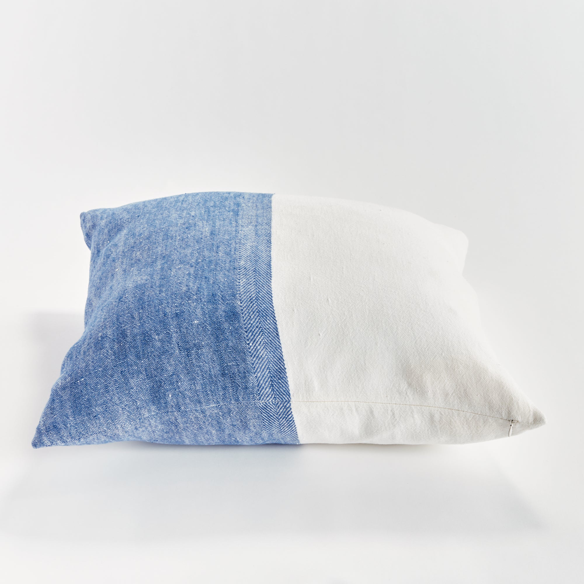 Half blue and half white square pillow on white background
