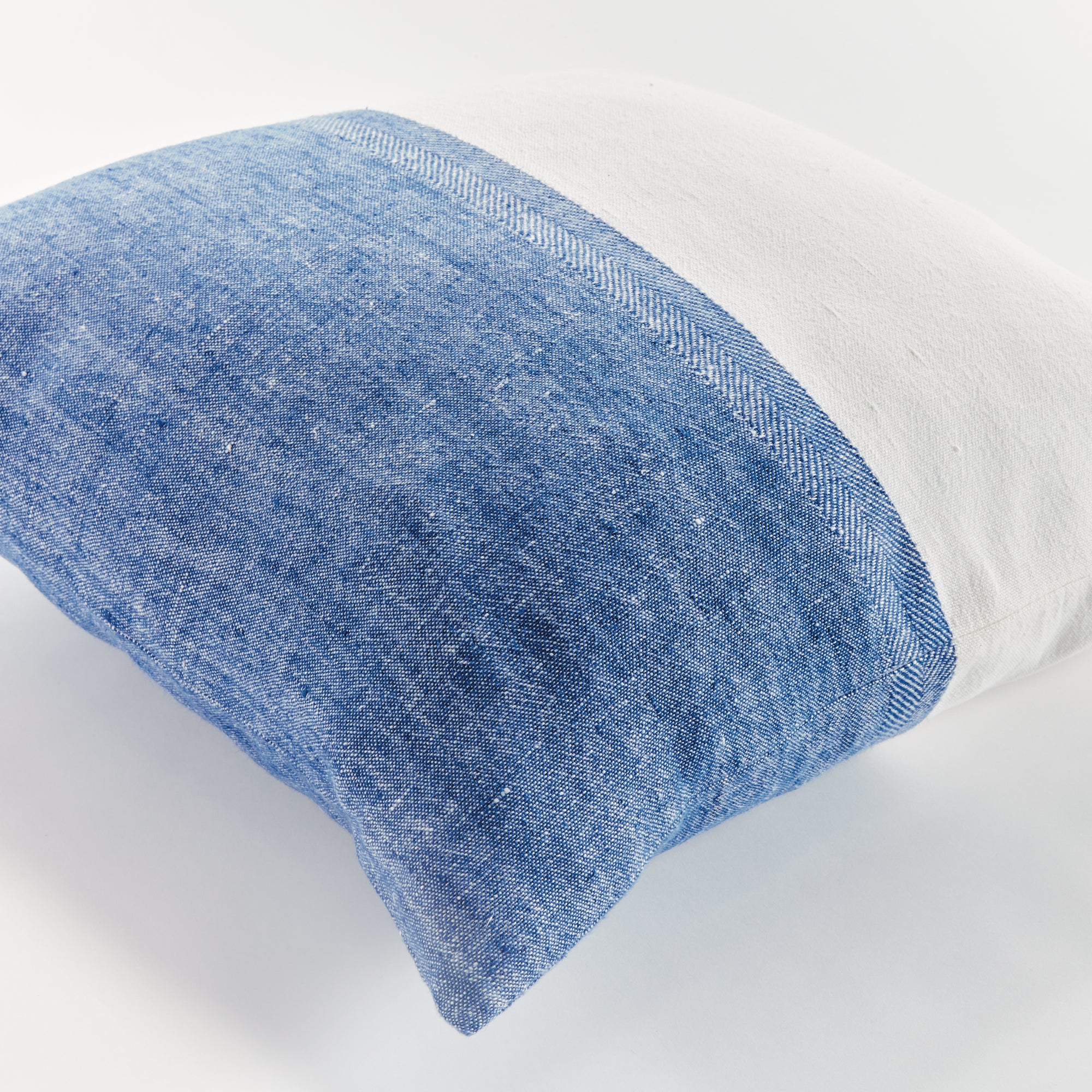 Half blue and half white square pillow on white background