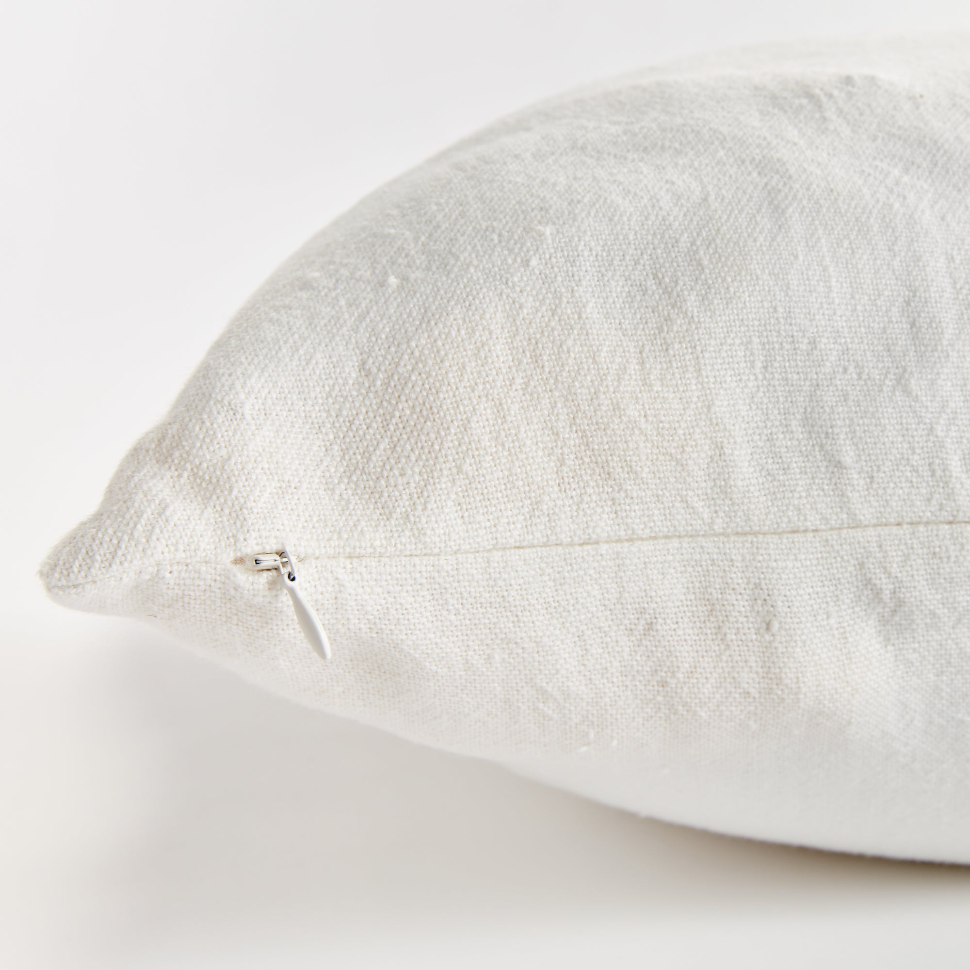 Close up of white square pillow zipper on white background
