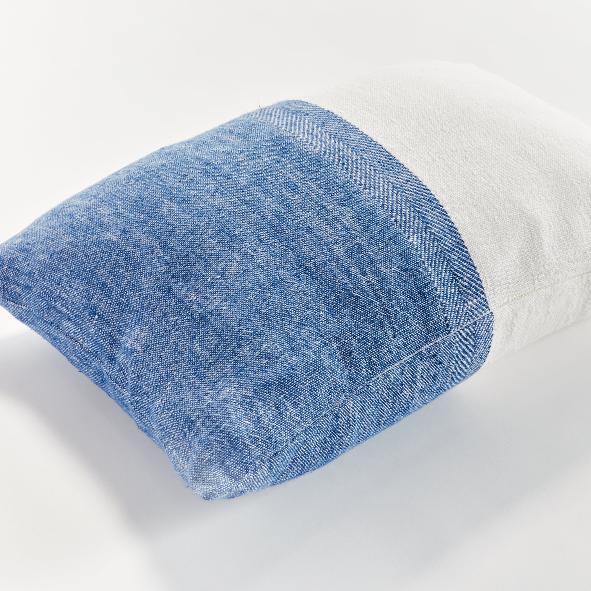 Half blue and half white rectangular pillow on white background