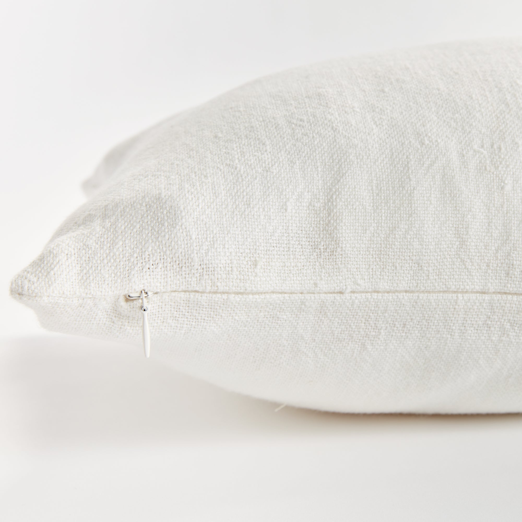 Close up of white rectangular pillow zipper on white background