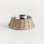 Wicker dog bowl with stainless steel insert on white background