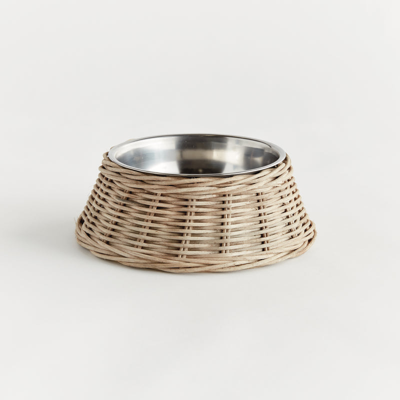 Wicker dog bowl with stainless steel insert on white background