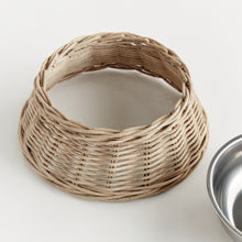 Wicker dog bowl with stainless steel insert on white background