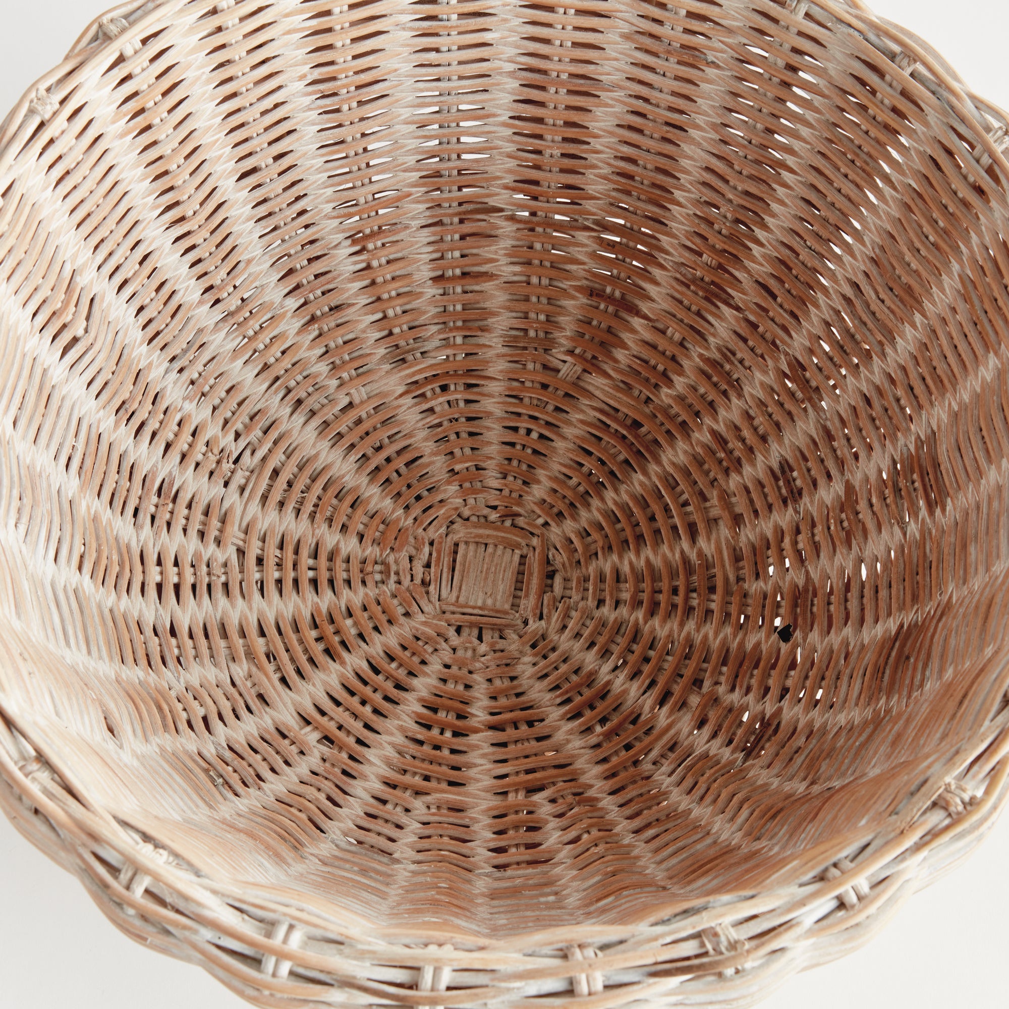 Top view of woven wicker bowl with square base on white background