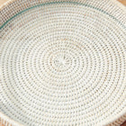 Close up of round woven tray with handles and glass insert