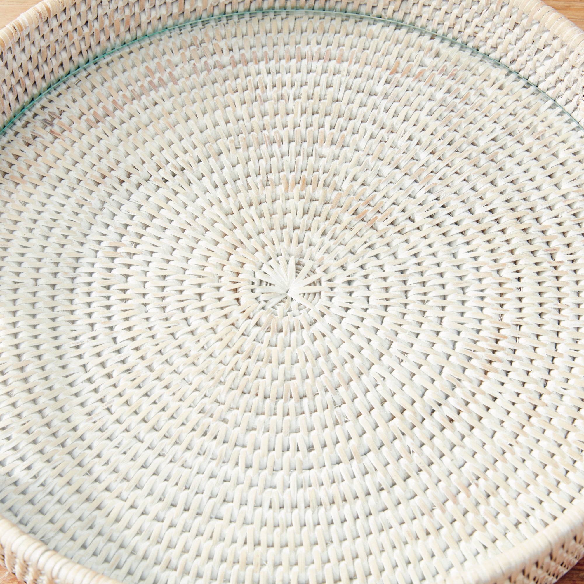 Close up of round woven tray with handles and glass insert