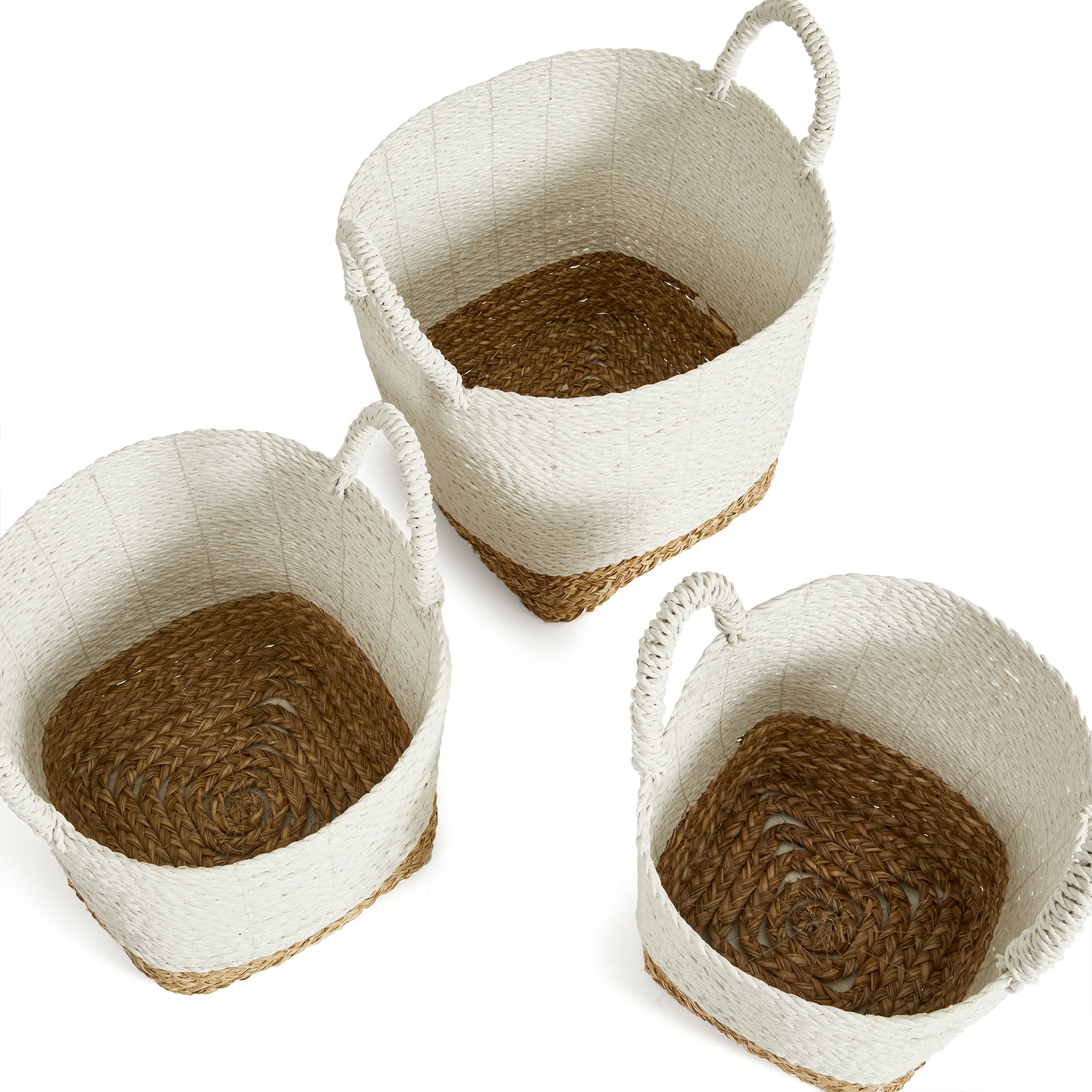 Top view of 3 white and natural woven baskets with handles on white background