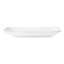 White decorative plate with scalloped edge on a white background
