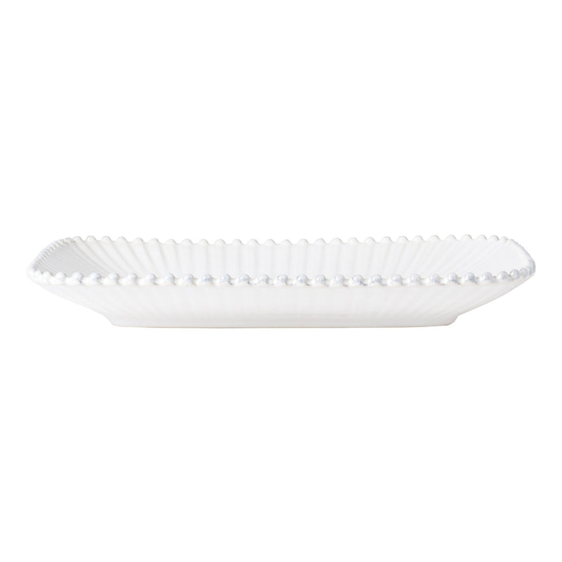 White decorative plate with scalloped edge on a white background