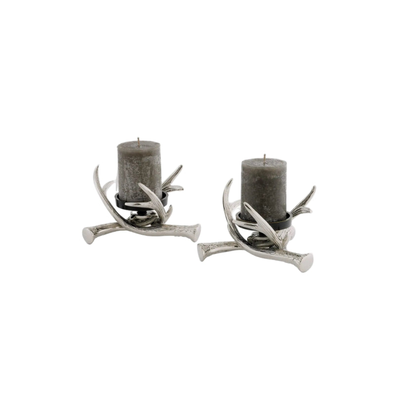 Two antler candle holders with gray candles on a white background