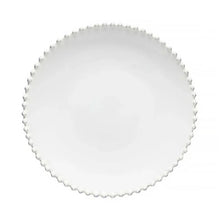 Round white plate with scalloped edge on a white background