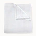 Folded white textured blanket on a white background
