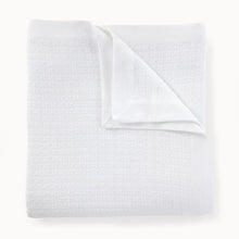 Folded white textured blanket on a white background