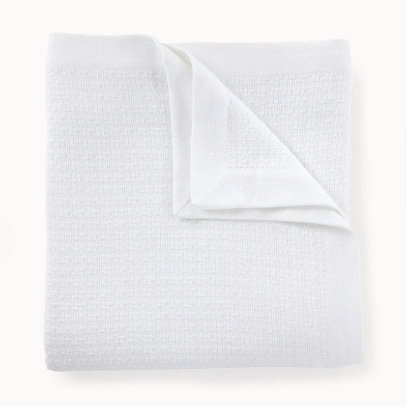 Folded white textured blanket on a white background
