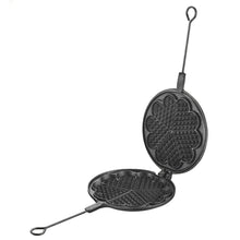 Cast iron waffle maker with a decorative design on a beige background