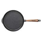 Black cast iron skillet with a wooden handle on a beige background