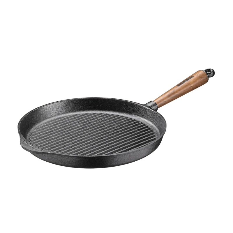 Black cast iron skillet with a wooden handle on a beige background