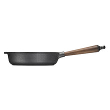 Black frying pan with a wooden handle on a beige background