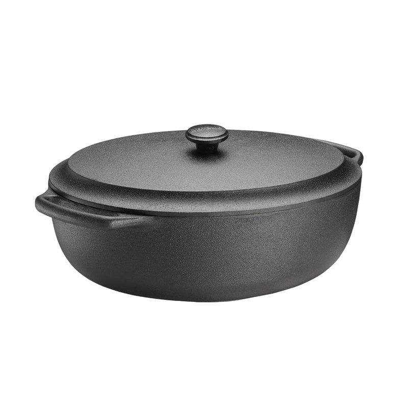 Black cast iron pot with lid on a beige background