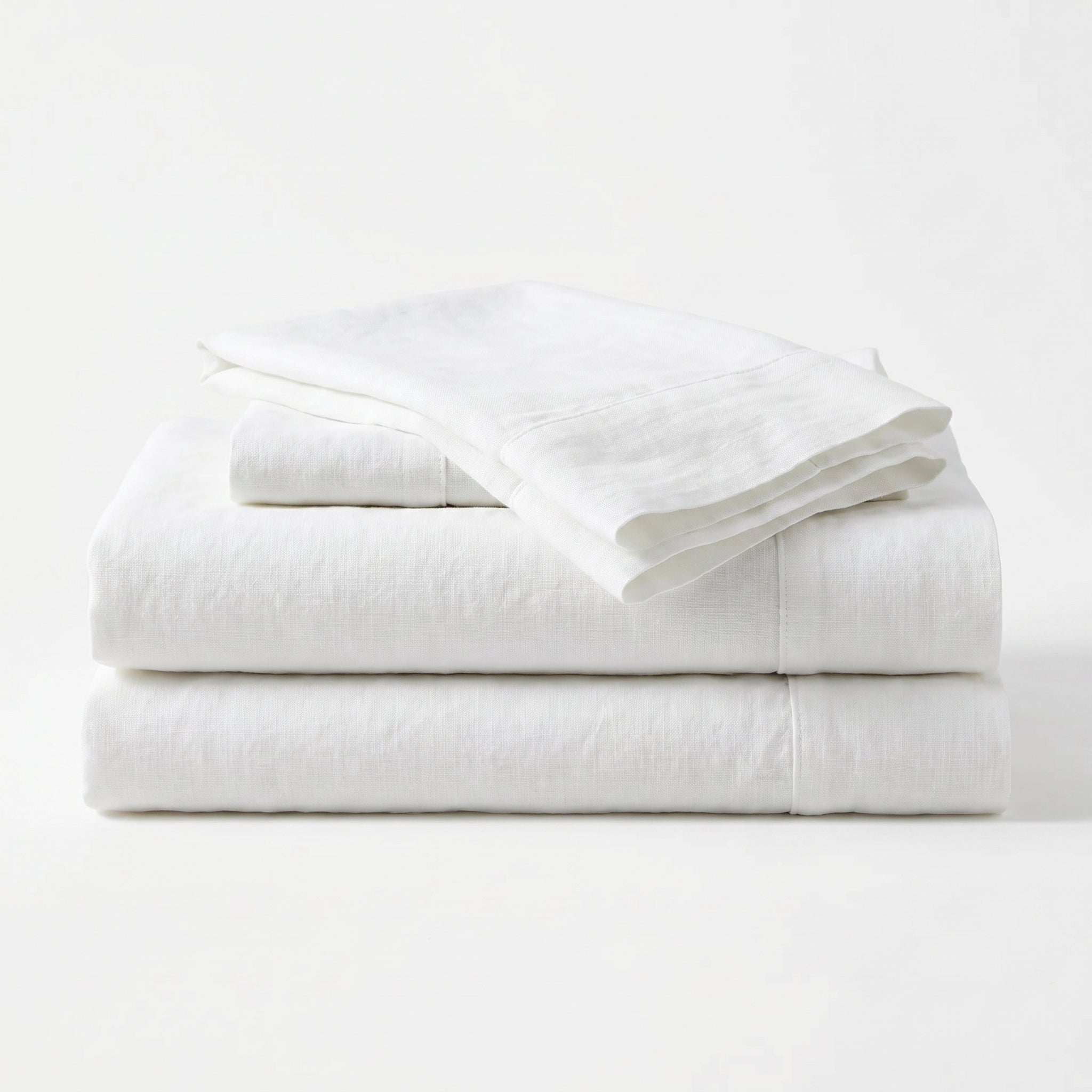 Stack of white folded towels on a white background