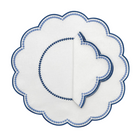 A set of four folded white linen napkins with a blue floral pattern.