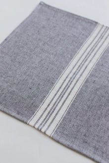 Gray linen placemat with white stripes on a light gray background