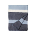 Folded blanket with blue, gray, and white stripes on a white background