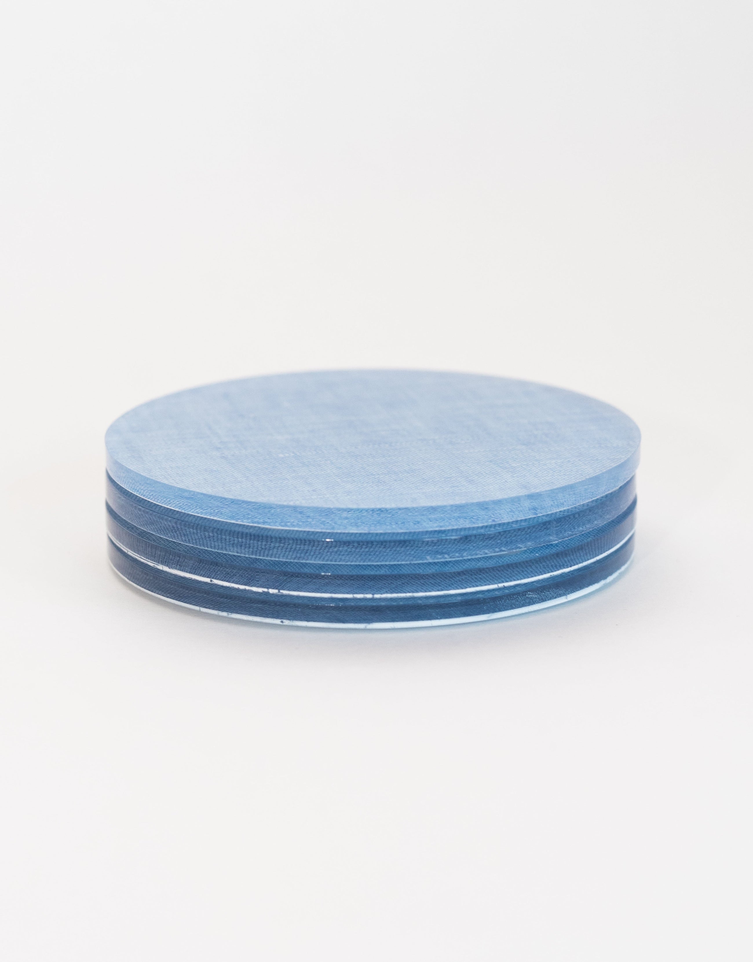Stack of blue ceramic coasters on a white background