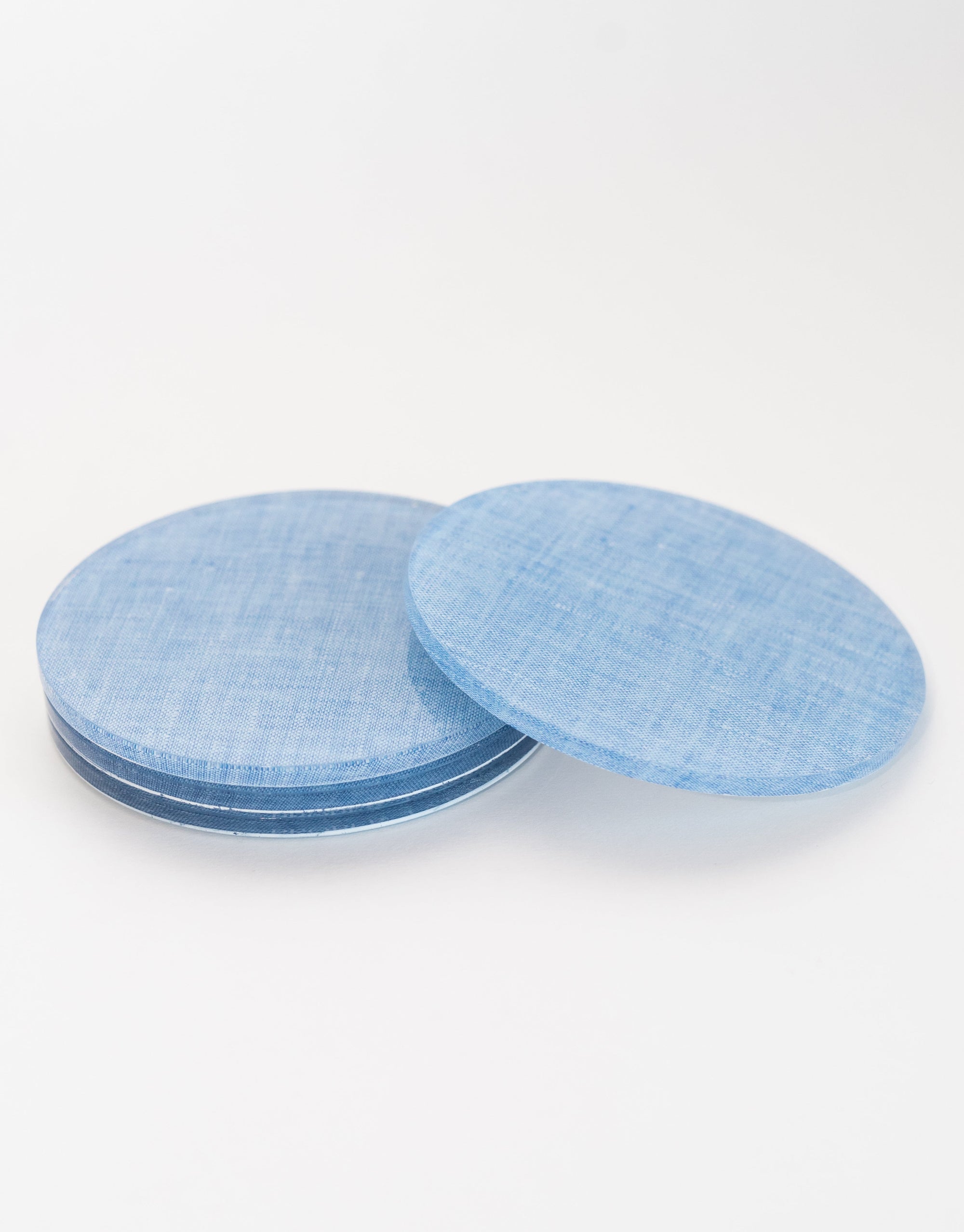 Three blue circular coasters stacked on a white background