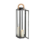 Black lantern with a wooden handle and two white candles inside on a light gray background