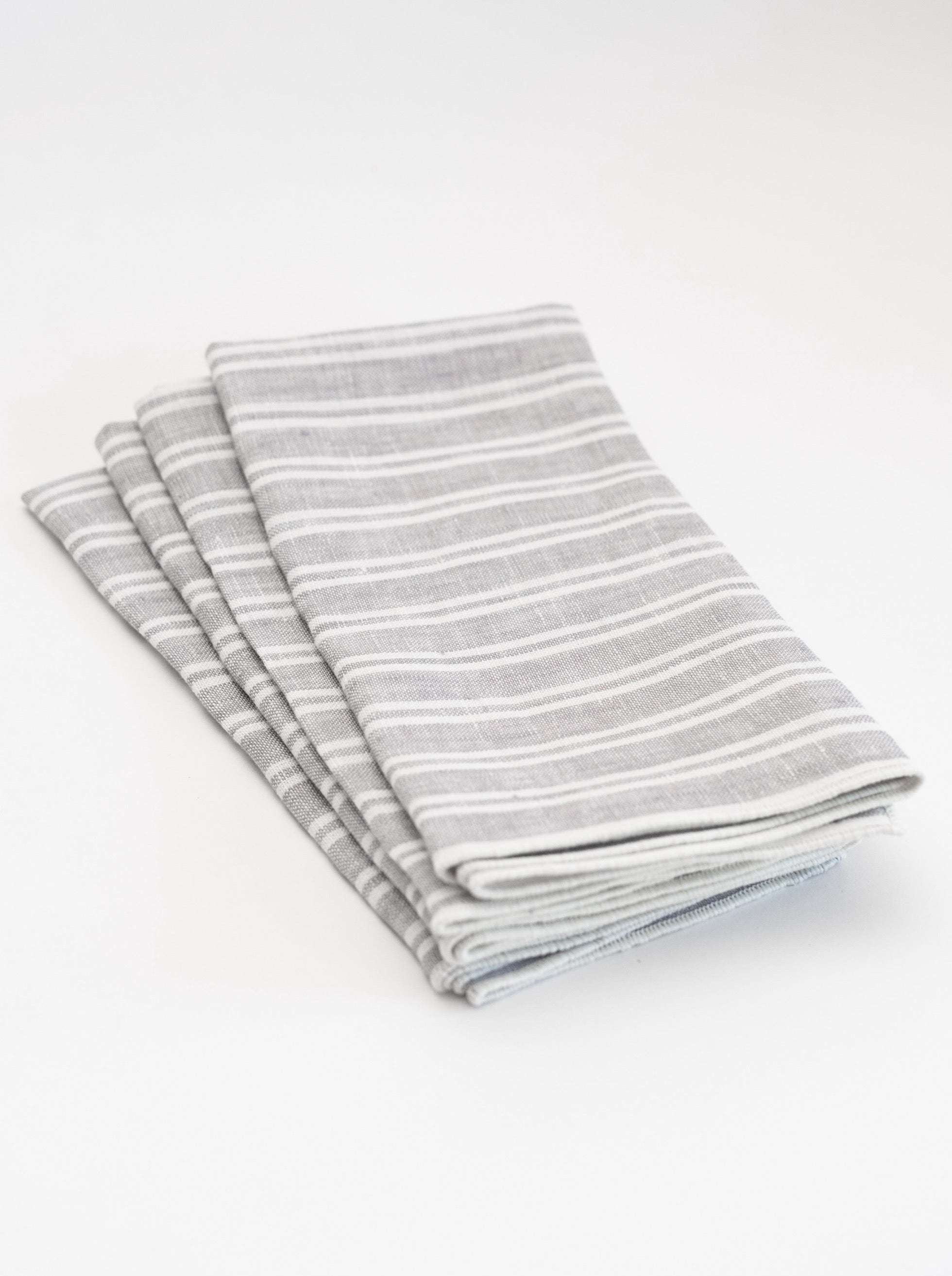 Set of four striped gray and white napkins on a white background