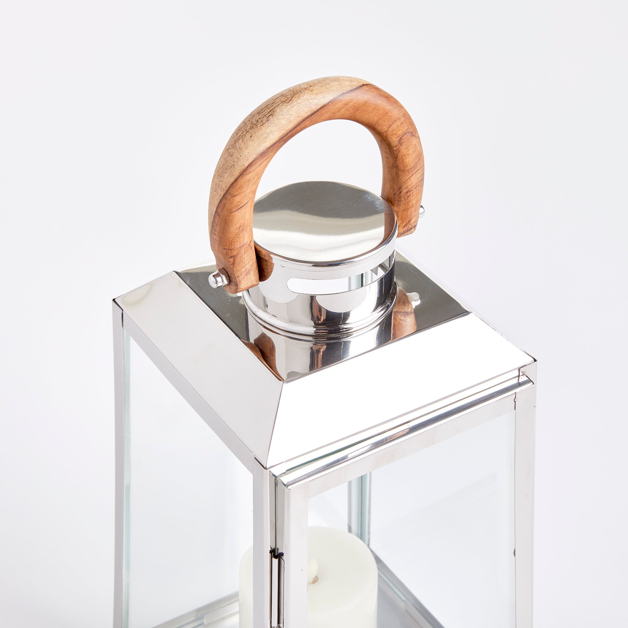 Chrome and glass lantern with a wooden handle on a white background