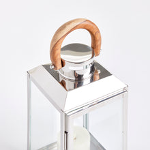 Chrome and glass lantern with a wooden handle on a white background