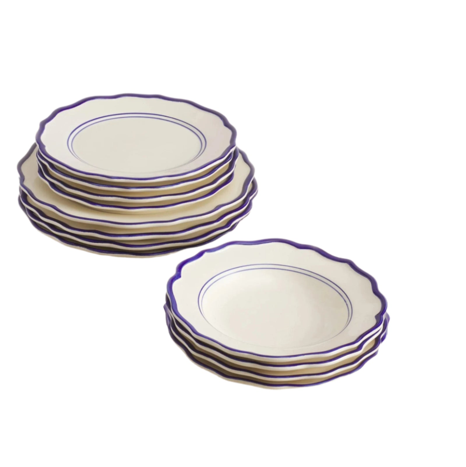 Set of 12 white ceramic dinner plates, salad plates and pasta bowls with blue rims on a beige surface