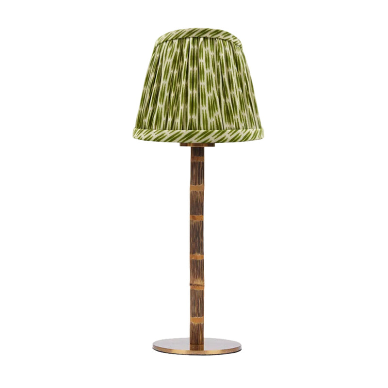 Table lamp with a green patterned shade on a white background