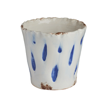 Ceramic cup with blue abstract design on a white background