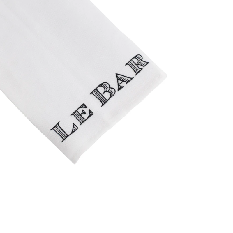 White napkin with 'LE BAR' printed in black on a white background