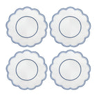 A set of four round placemats with blue scalloped edges and embroidered details in the center.
