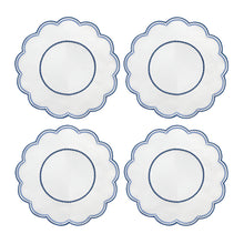 A set of four round placemats with blue scalloped edges and embroidered details in the center.