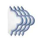 A set of four folded white linen napkins with a blue floral pattern.
