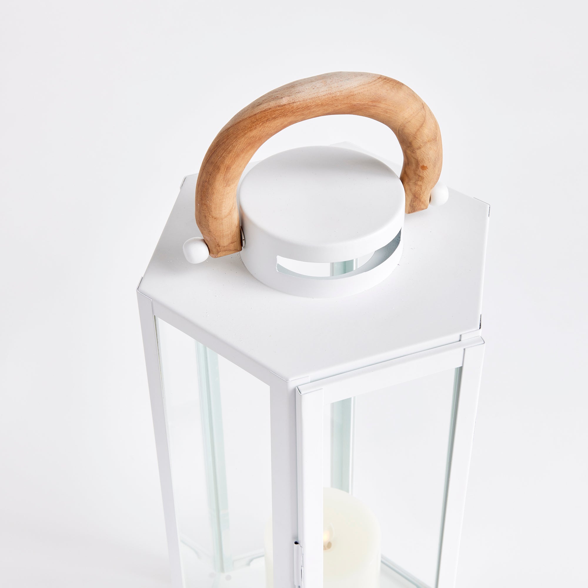 White lantern with a wooden handle and glass sides on a white background