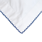 White fabric with blue embroidery on a white background