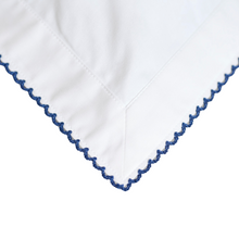 White fabric with blue embroidery on a white background
