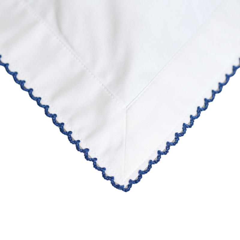 White fabric with blue embroidery on a white background