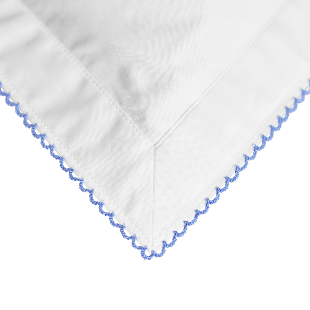 White fabric with blue embroidery on a white background