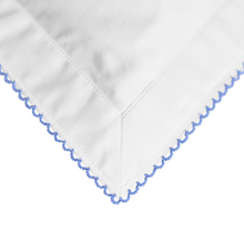 White fabric with blue embroidery on a white background