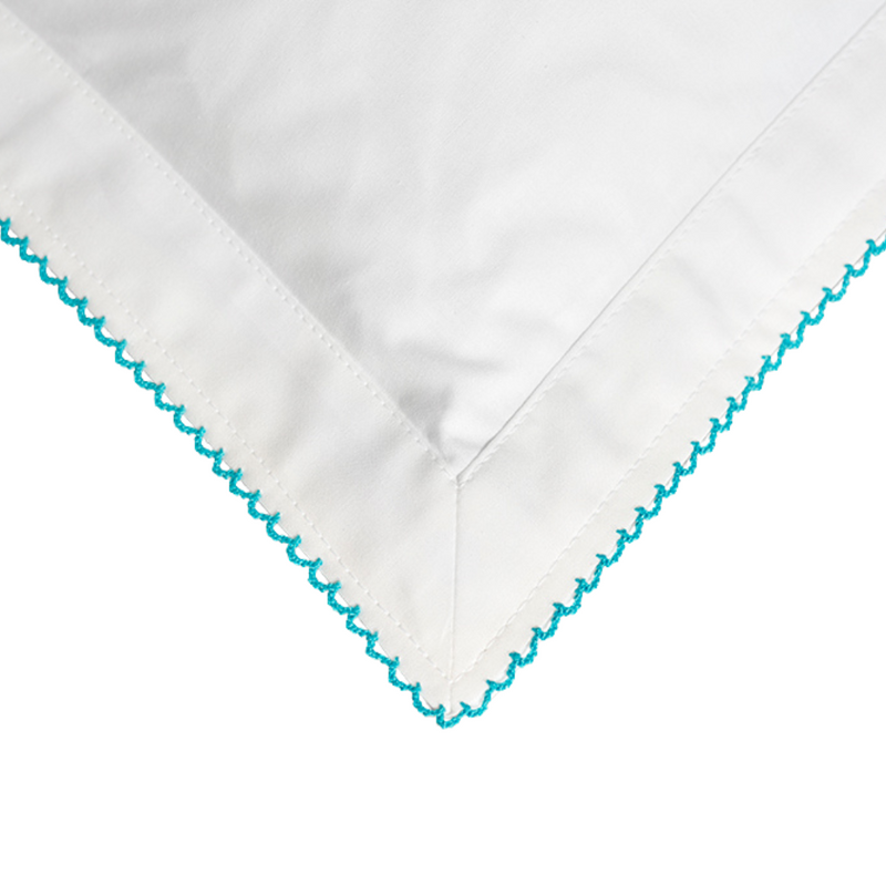 White fabric with  turquoise embroidery on a white background