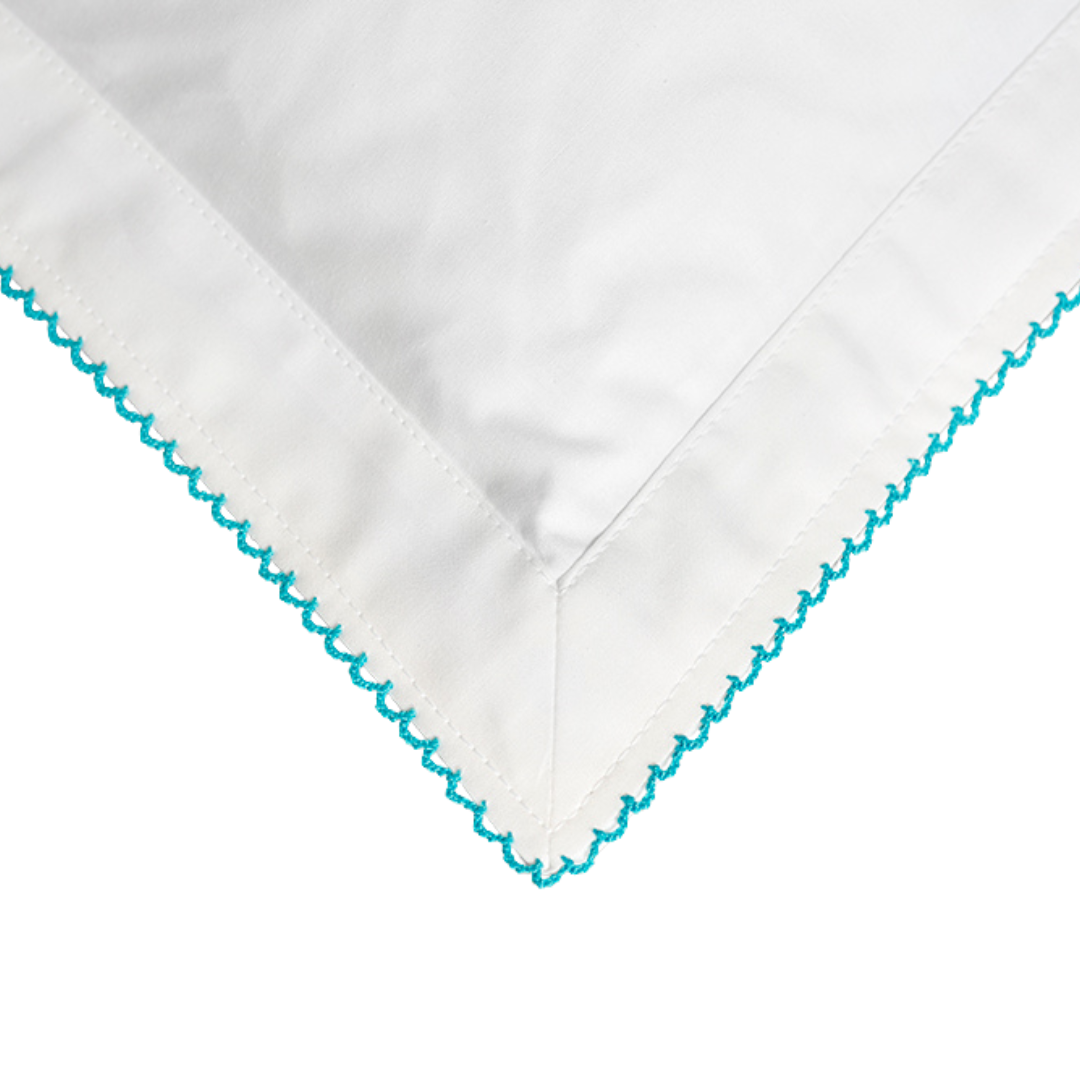 White fabric with turquoise embroidery on a white backgroun