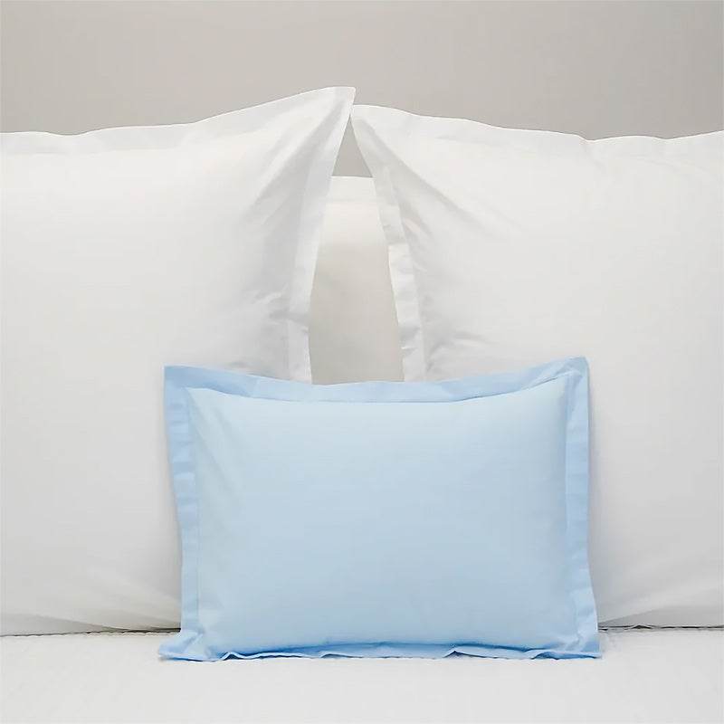 Light blue pillowcase on a bed with white pillows